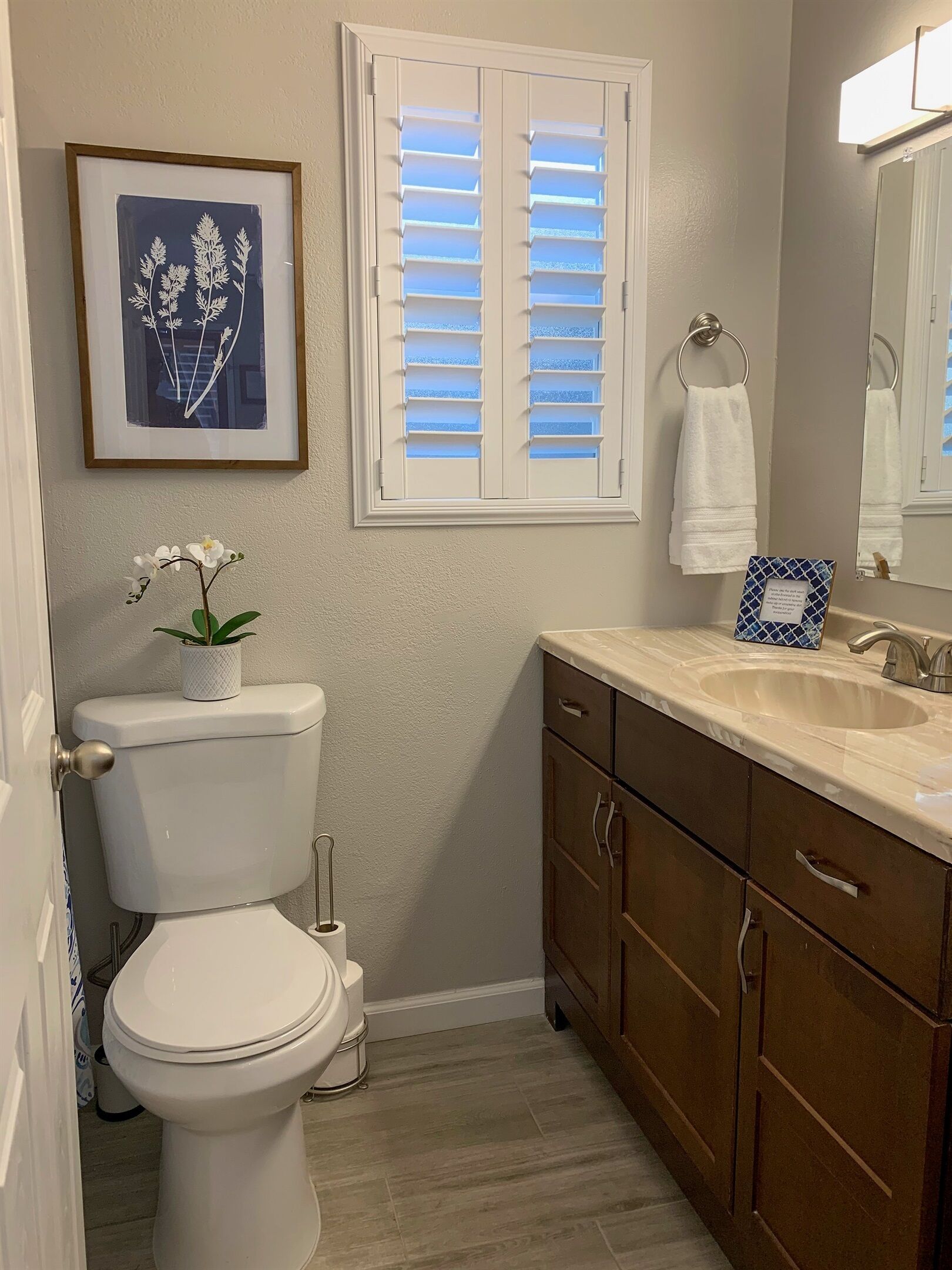 A bathroom with a toilet, sink, and cabinet.