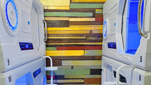 Fila de unidades blancas y modernas, de aspecto multifuncional con iluminación azul, numeradas del 5 al 10, frente a un colorido panel de madera.