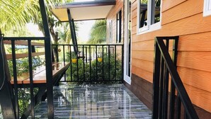A wooden house with a porch, a staircase, and a metal railing. - At Thara Aonang (Krabi)