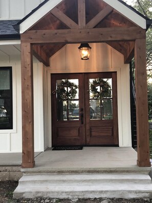 A wooden porch with a lantern, a double door with glass panels, and a doormat. - GORGEOUS!!!  Open concept renovation. Wawasee, Oakwood Park water front! (Syracuse)