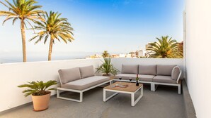 A rooftop terrace with a white sofa set, a coffee table, and a potted plant. - Villa Nestor (Ingenio)