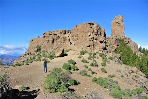 A rocky landscape with a person standing in the foreground. - Villa Nestor (Ingenio)