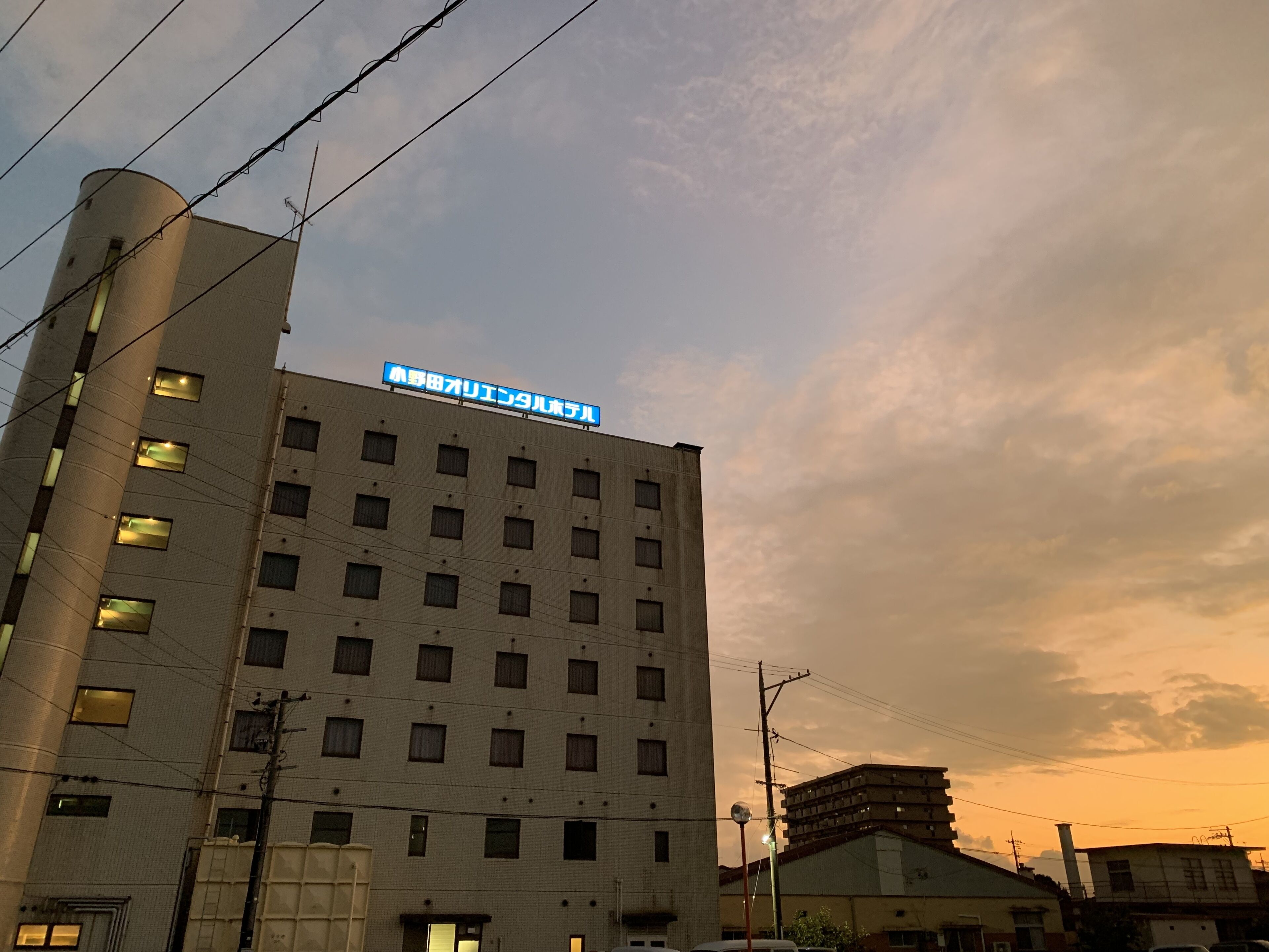 A multi-story building with a sign in Japanese, multiple windows, and a visible power line.