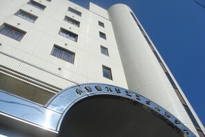 A modern building with a curved entrance and a sign in a foreign script. - Onoda Oriental Hotel (Sanyoonoda)