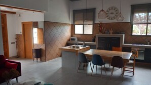 A modern kitchen with a central island, a dining area with chairs, and a living space with a sofa and a coffee table. - Mapagog: CASA PIXAVI, Surrounded by orange trees between the mountains and the beach <br> (Castello)