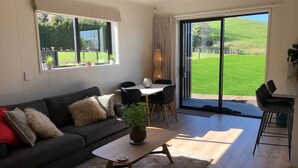 Een woonkamer met een bank, salontafel en een eethoek met stoelen.