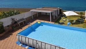 A swimming pool with a view of the sea and mountains.