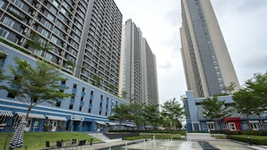 A modern building with multiple floors, a courtyard with a fountain, and outdoor seating areas.