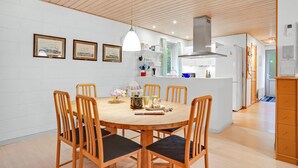 A modern kitchen with white cabinets, a stainless steel range hood, and a built-in oven.
