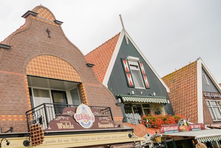A traditional Dutch building with a bakery sign, a restaurant sign, and a cafe sign.