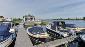 A marina with several boats docked at wooden piers. - Bright and Comfortable Houseboat (Aalsmeer)