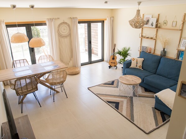 A spacious living area with a dining table, chairs, a sofa, and a coffee table.