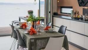 A dining table set with a tablecloth, chairs, and tableware. - The Oceanfront (Trondheim)