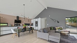 A modern living space with a kitchen, dining area, and seating area. - The Oceanfront (Trondheim)