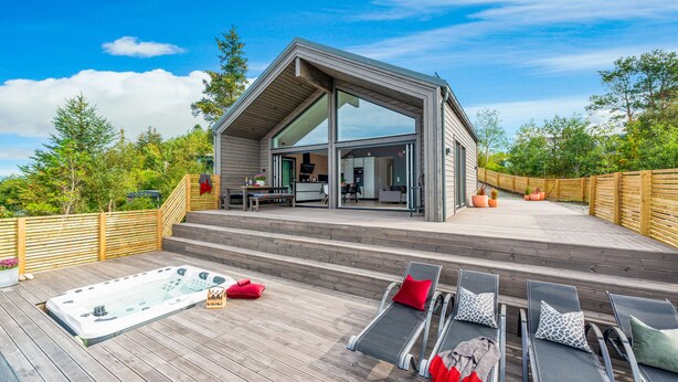 A modern house with a deck, a hot tub, and outdoor seating. - The Oceanfront (Trondheim)