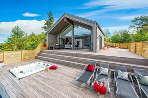 A modern house with a deck, a hot tub, and outdoor seating. - The Oceanfront (Trondheim)