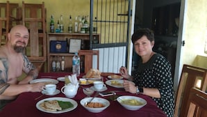 Une table à manger avec des assiettes, des bols et des bouteilles.
