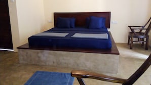Une chambre à coucher avec un lit, des oreillers, une chaise et un petit tapis.