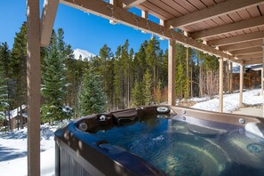 A hot tub under a wooden pergola with a snowy forest and mountains in the background. - Blue River Pines Home: Peaceful, Hot Tub, Views (Breckenridge)