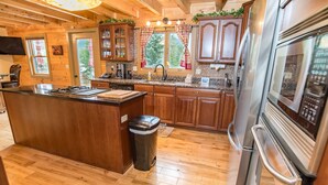 A spacious kitchen with wooden cabinets, a granite countertop, and stainless steel appliances. - Bear Creek Mining Lodge: Mountain Style, Hot Tub (Breckenridge)