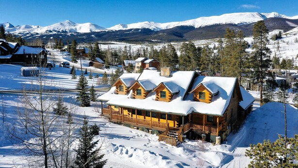 A log cabin with multiple rooms, surrounded by snow-covered landscape and mountains. - Bear Creek Mining Lodge: Mountain Style, Hot Tub (Breckenridge)