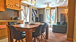 Una cocina acogedora con armarios de madera, una mesa de comedor con sillas y un sofá en la zona de estar.