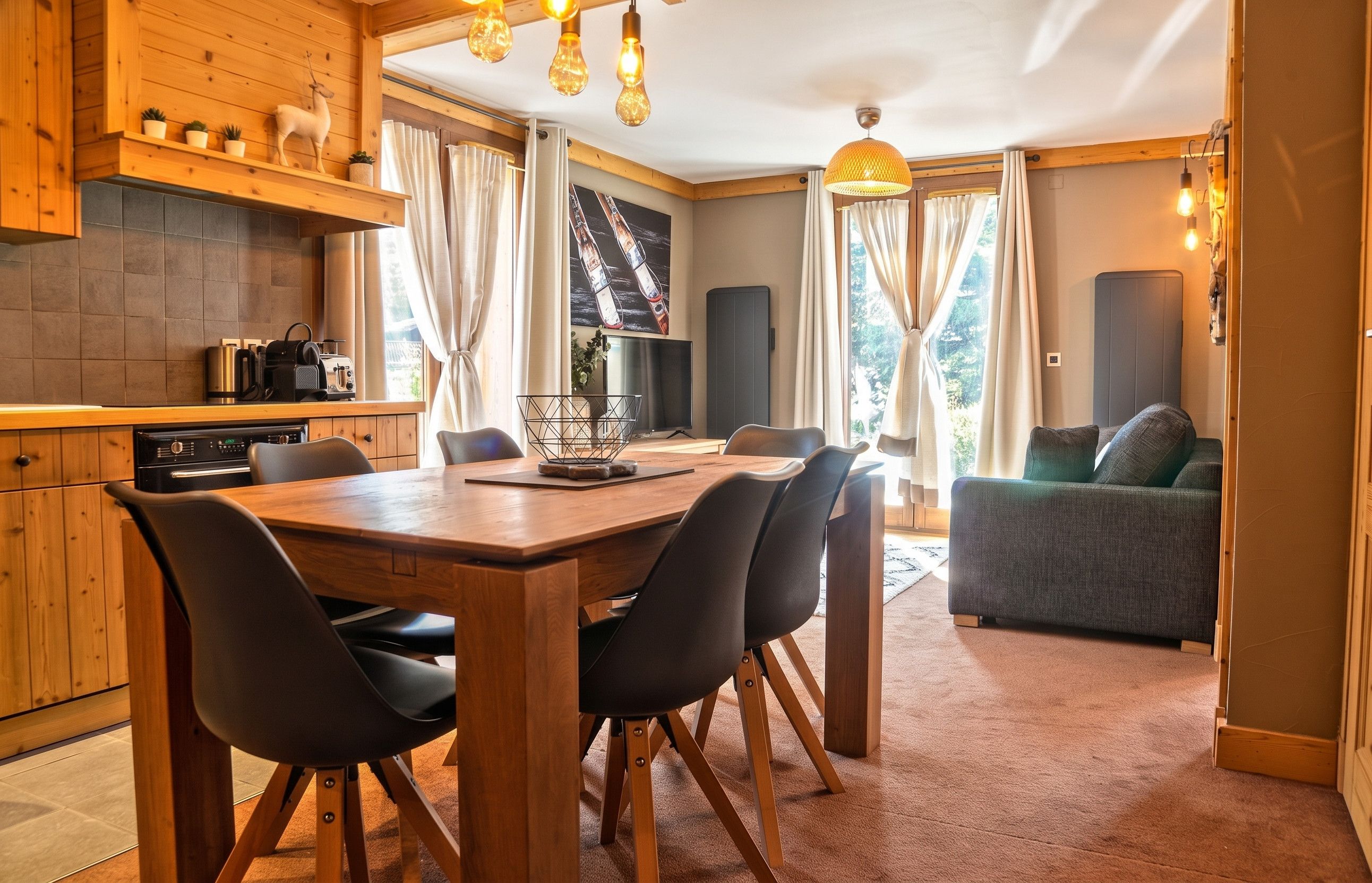 Una cocina moderna con armarios de madera, una mesa de comedor con sillas y una sala de estar con un sofá.