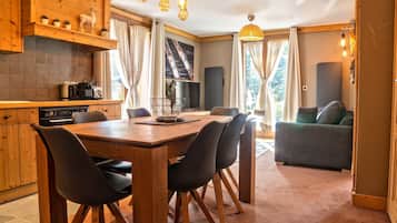 Una cocina moderna con armarios de madera, una mesa de comedor con sillas y una sala de estar con un sofá.