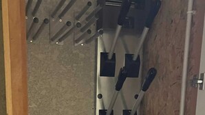 A room with a wooden door, a metal electrical panel with multiple switches, and a textured wall. - Homerez - Apt. Mountain View - Les Deux Alpes (Les Deux Alpes)