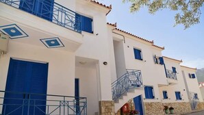 Un edificio blanco con contraventanas azules y fachada de piedra.