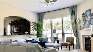 A living room with a sofa, armchair, and a fireplace. - South Hampton 75” TV Golf Club Saint Augustine Golf Course View! (St. Augustine)