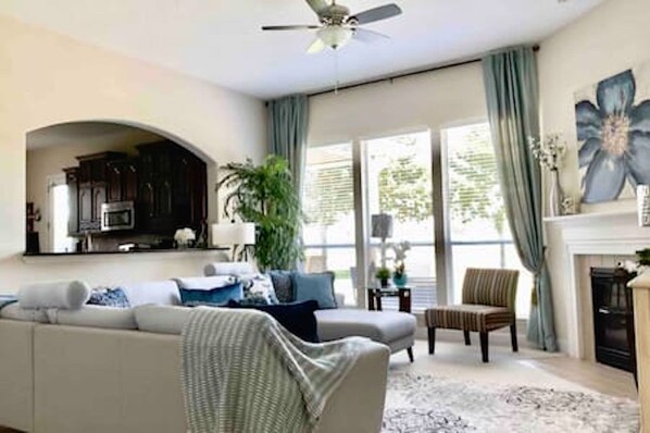 A living room with a sofa, armchair, and a fireplace.