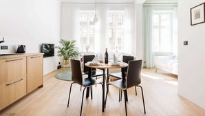 A modern dining area with a round table, black chairs, and a wooden cabinet. - Comfortable Studio in the Center | Close to the Park and the Fair (Poznan)