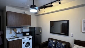 Executive Studio | Living area | 50-inch Smart TV with cable channels, TV - Cozy Studio Apartment (Lapu-Lapu)