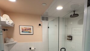 A modern bathroom with a glass-enclosed shower, a toilet, and a sink. - The Cabot Lodge (Beverly)