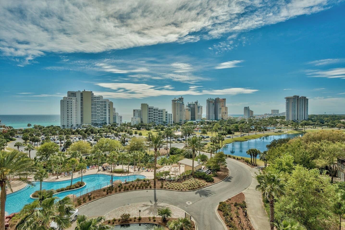 A resort with multiple high-rise buildings, a large swimming pool, and a golf course.