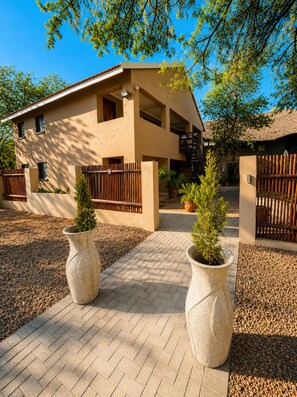 A modern two-story house with a flat roof, a balcony, and a staircase leading to the upper floor. - Echo Mountain Inn (Thabazimbi)