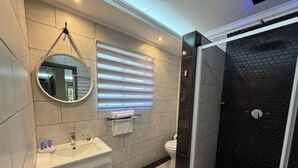 Un baño moderno con tocador, inodoro y ducha con cerramiento de vidrio.