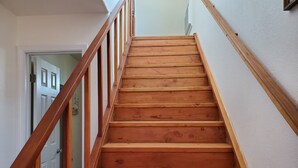 Una escalera de madera con barandilla que conduce a un piso superior.
