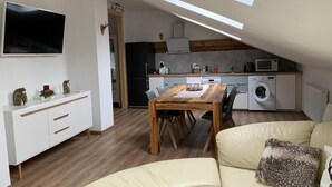 Un appartement moderne comprenant un coin repas, une cuisine et un salon.