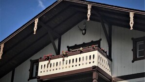 Un bâtiment doté d’un balcon, d’une balustrade en bois et d’une tête d’animal fixée au mur.