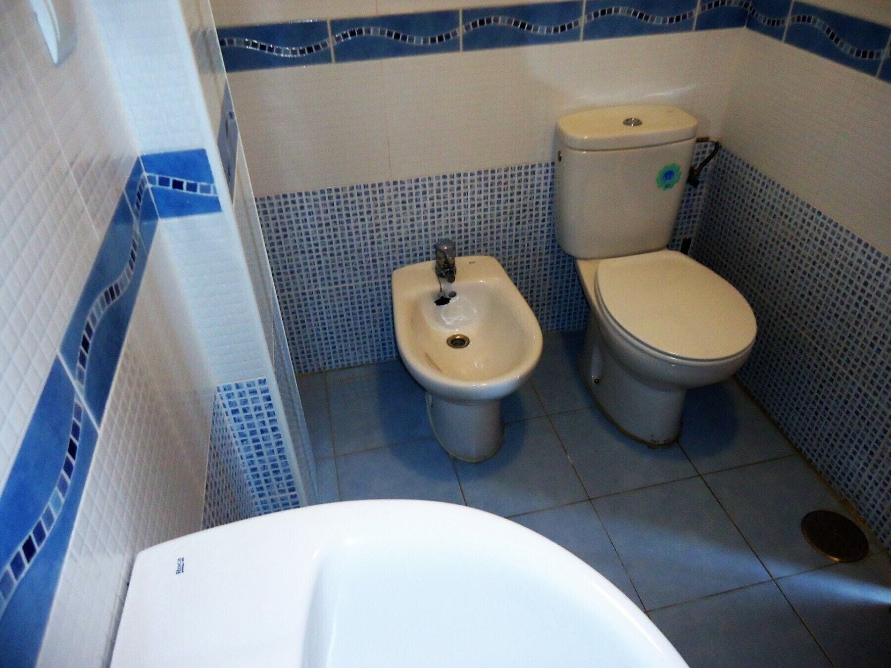 Un baño con bidé, inodoro y bañera.