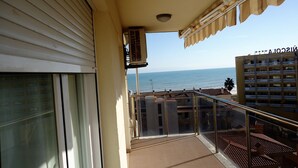 A balcony with a view of the sea, a building with balconies, and a window with blinds. - P. Maritimo 40 Lateral LEK (Peñiscola)
