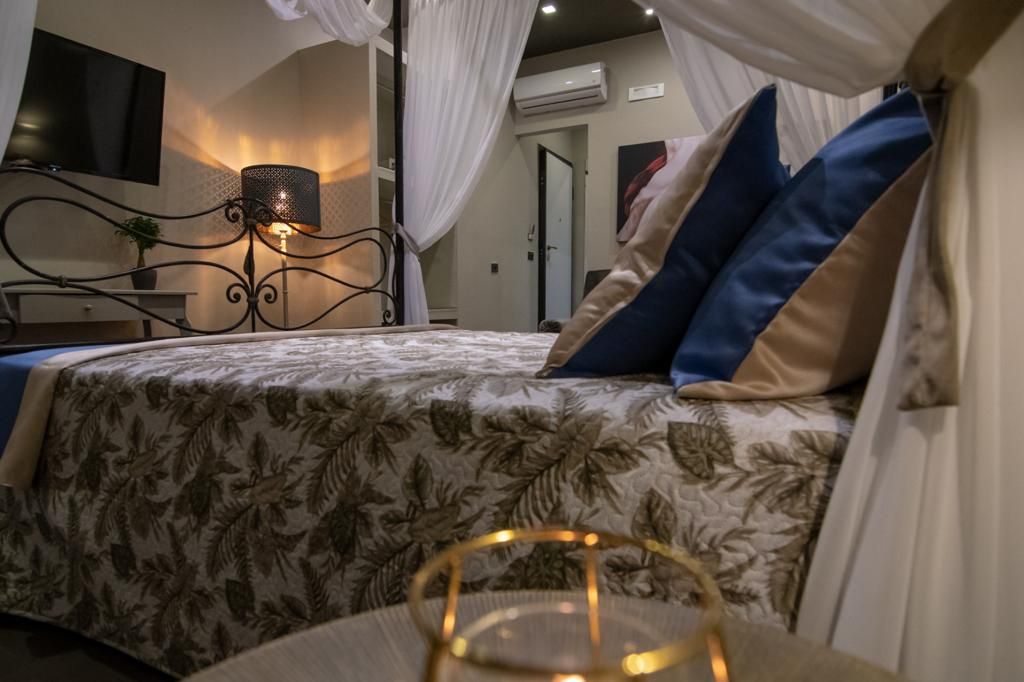 Un dormitorio con cama con dosel, una lámpara de noche y vista al pasillo.