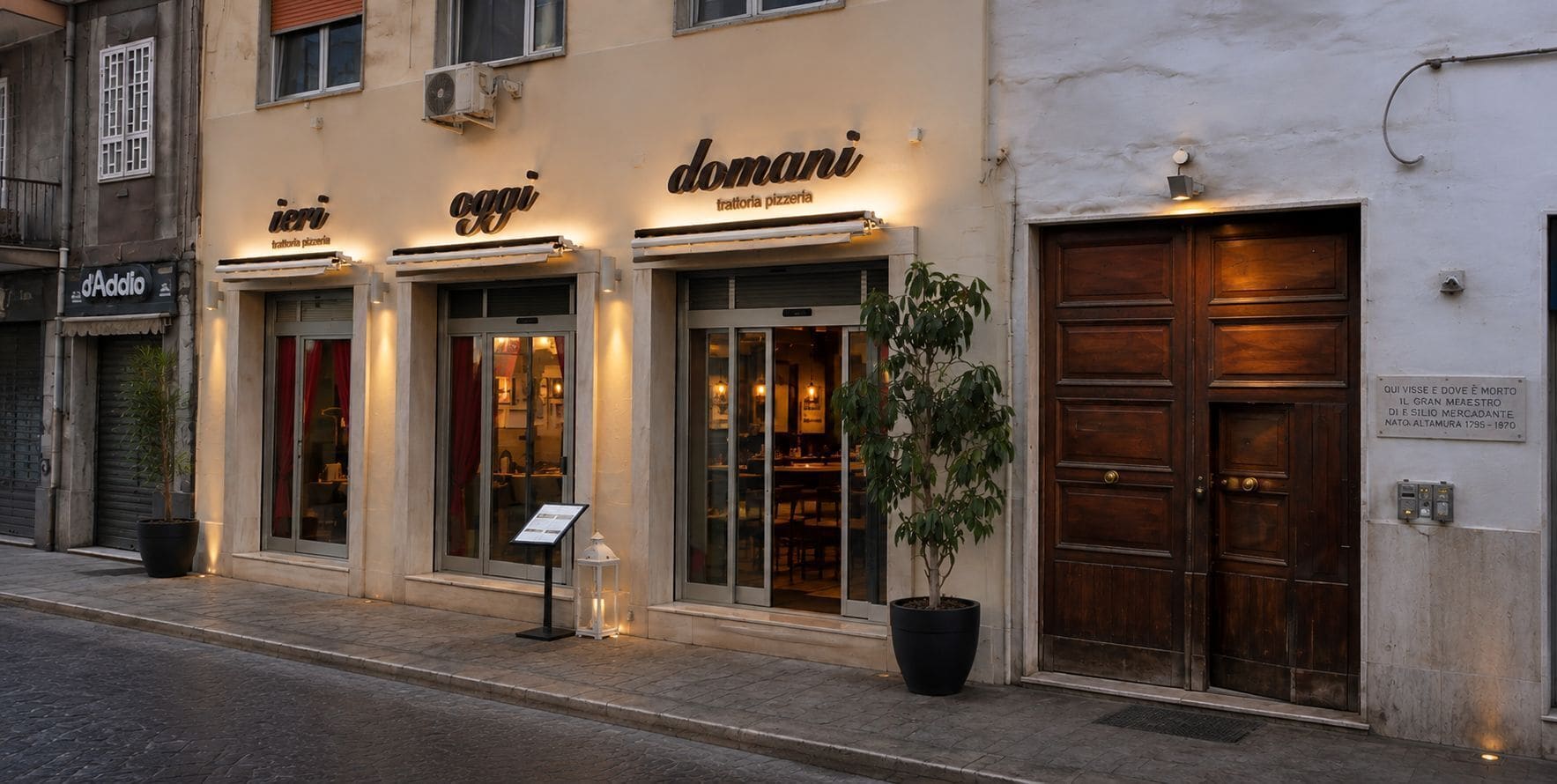 Een gebouw met drie etalages, elk met een bord waarop trattoria pizzeria staat. Voor de middelste etalage staat een bloempot.
