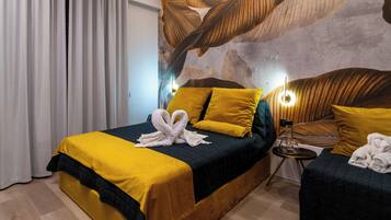A hotel room with a bed, a side table, and a wall mural.