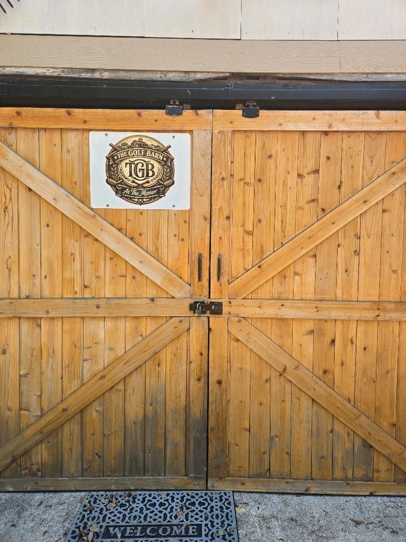 A wooden double door with a sign above it.