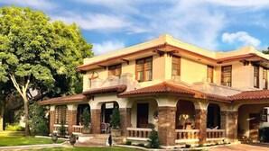 A two-story house with a tiled roof, multiple windows, and a front porch. - The Lancaster Manor B&B (Gainesville)
