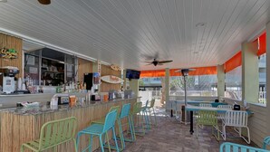 An outdoor bar area with a counter, bar stools, and tables. - Direct water view from Balcony-Pool (Tampa)