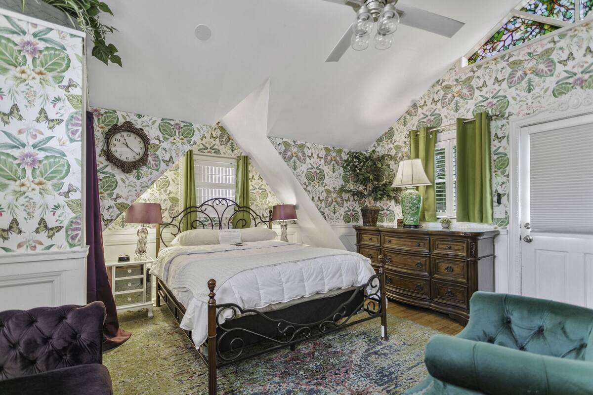 Un dormitorio con cama, cómoda, mesita de noche y una silla.